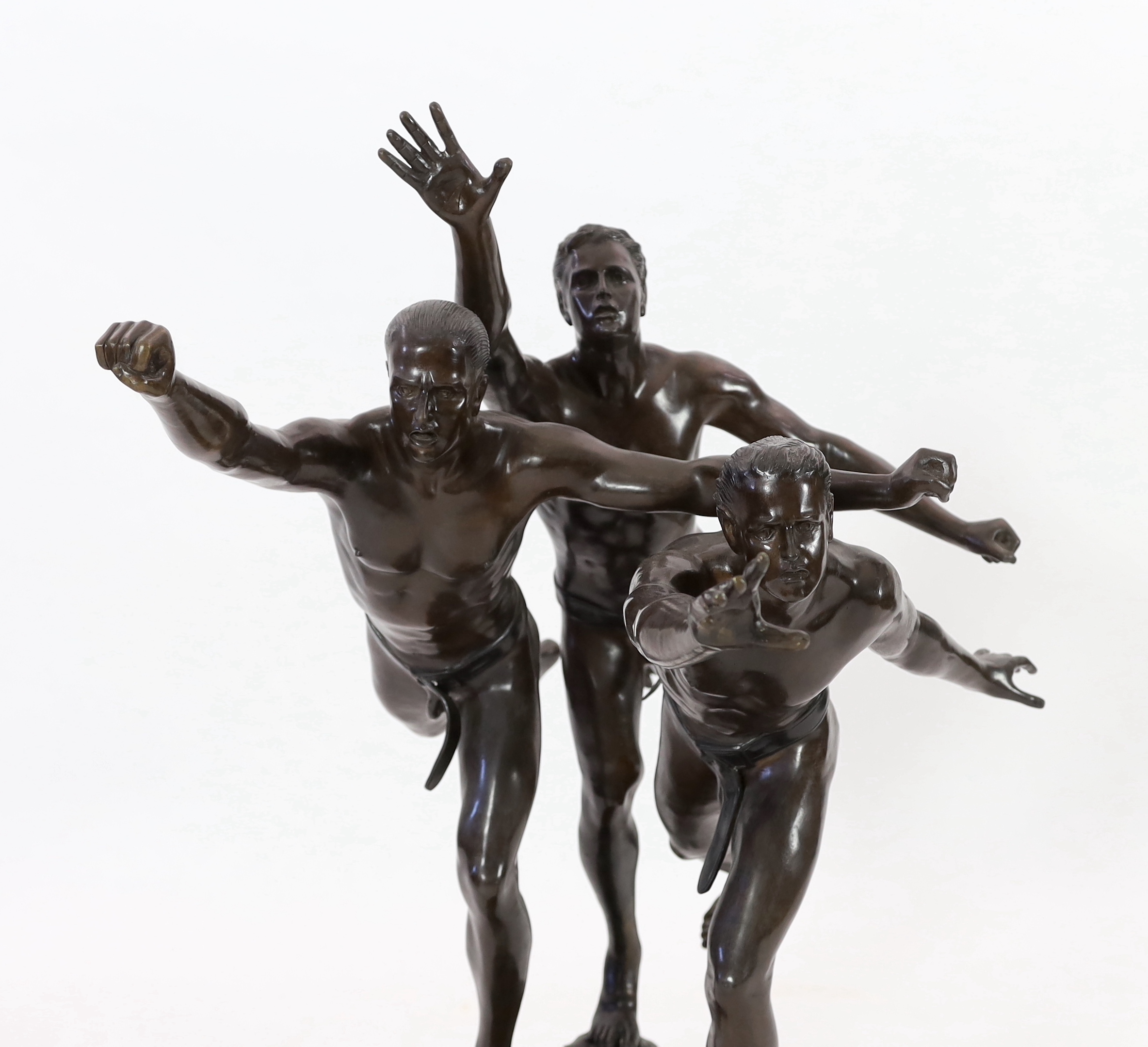 After Alfred Boucher (French, 1850-1934). A large bronze group of three runners at the finishing line, 'Au But', 128cm long, 78cm deep, 111cm high